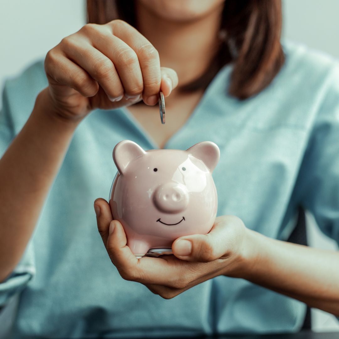 a person adding money to a piggy bank