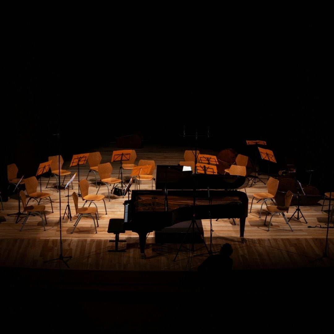 orchestra chairs and piano on stage without any players